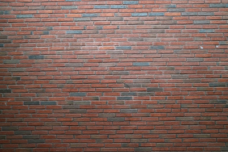 a lone street sign is attached to the side of a brick wall