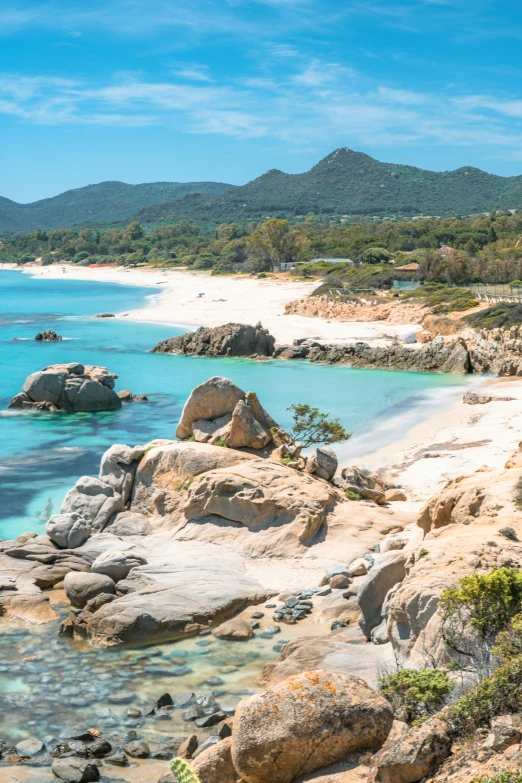 there is rocks and sand on the beach and water