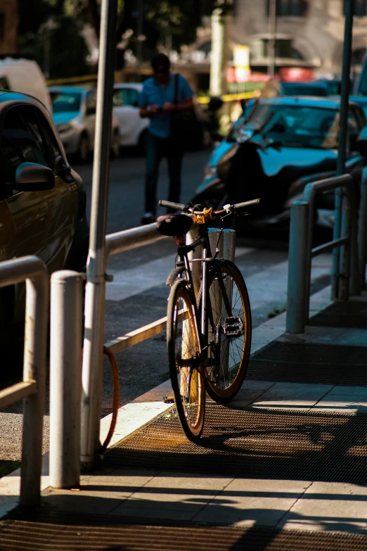 a bicycle leaning against a railing and some cars