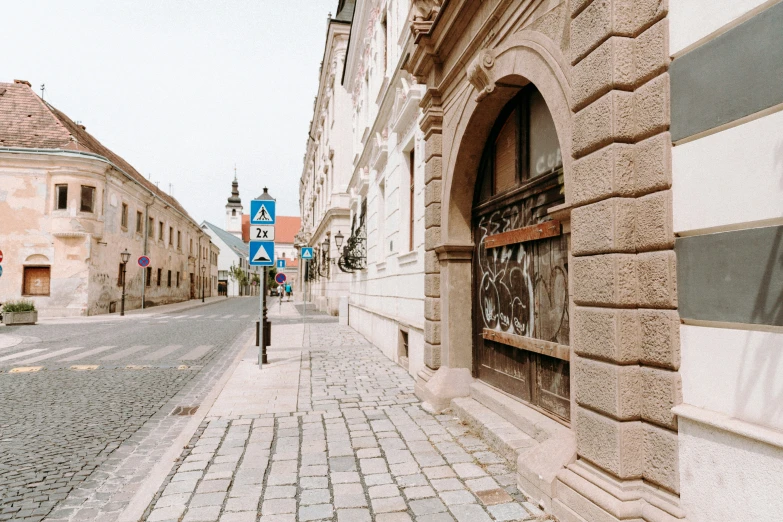 street view of city buildings near a cobblestone sidewalk