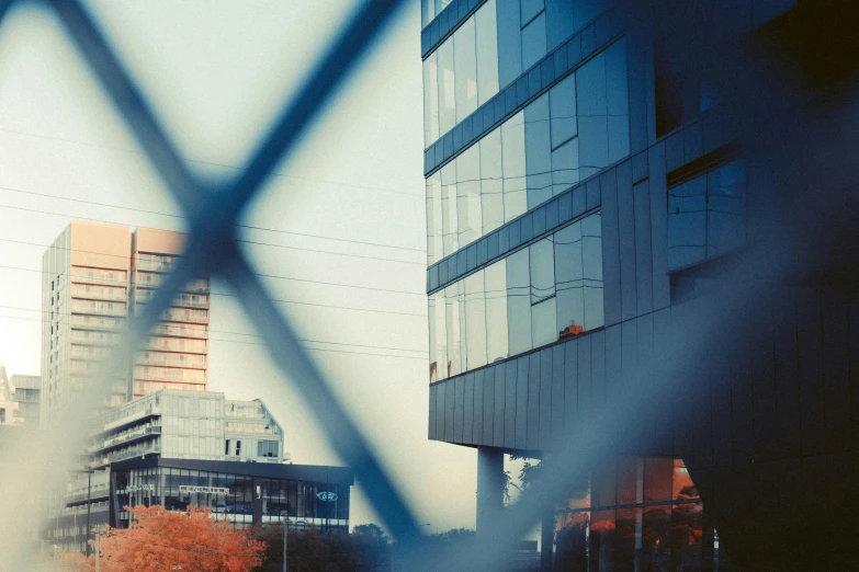 a large building is behind a wire fence