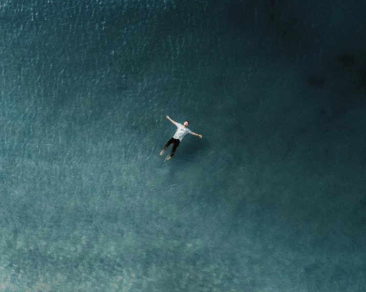 a man in the water above an ocean