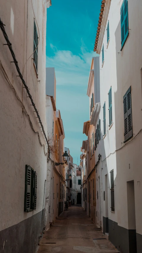 a narrow alley way with a street lined with buildings