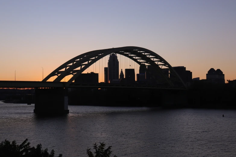 an image of a city at sunset with a bridge going over it
