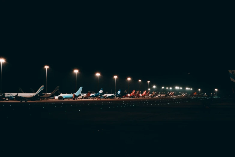 airplanes parked on the tarmac in an airport at night