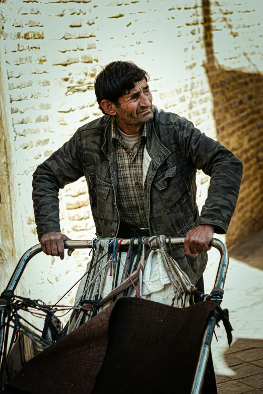 an indian man holding a very old looking bicycle