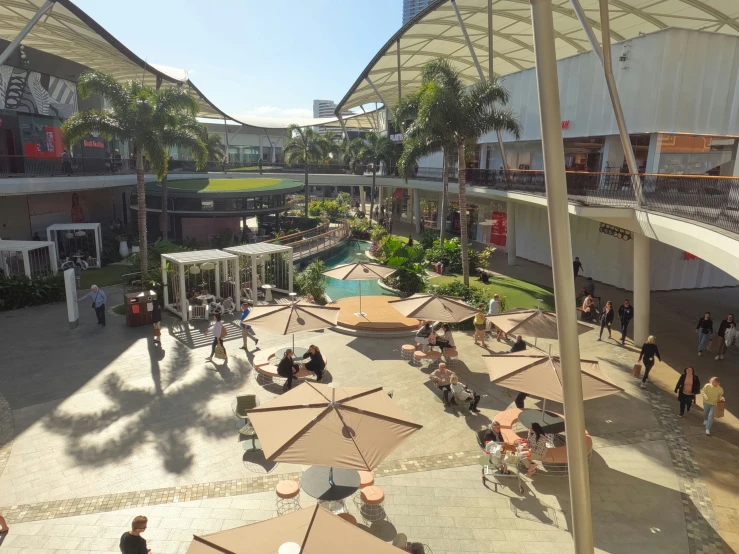 an overhead s of several tables and umbrellas in a public building