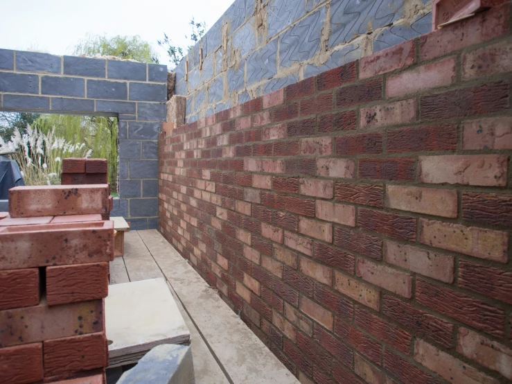 a wall made out of red bricks on top of cement