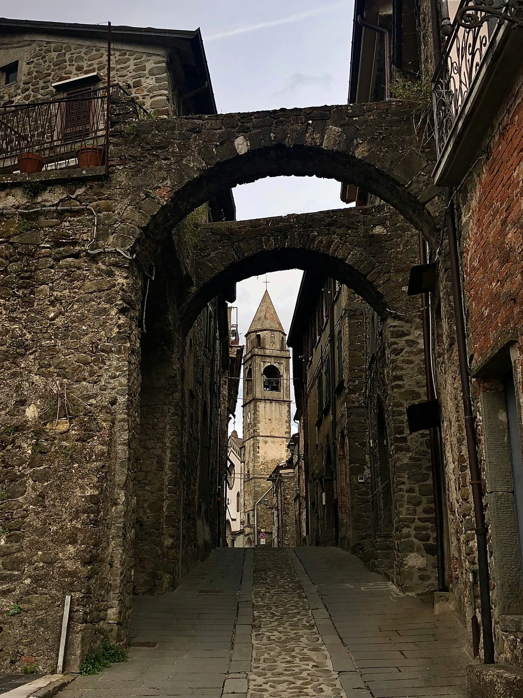 an old city has a wide stone walkway between some buildings