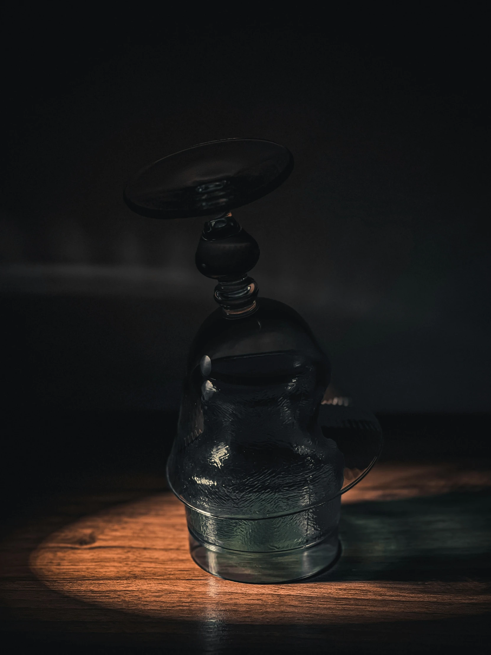 a black bottle and a grinder on a wooden table