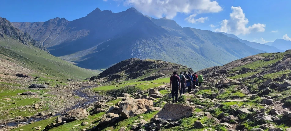 a group of people walking up a rocky mountain