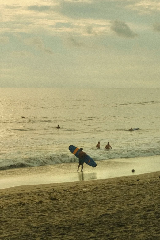 people in the ocean with surfboards under their arms