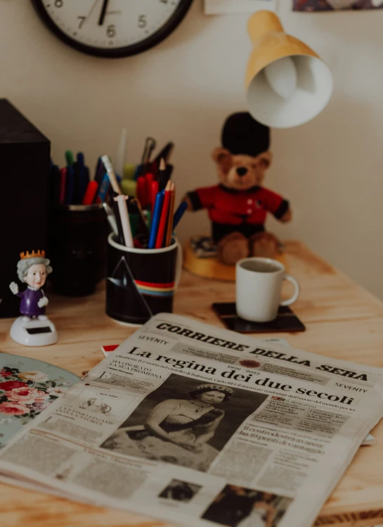 an old po and cup sit on a desk