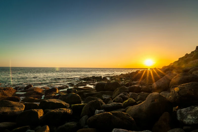 sunset over the ocean and rocky shore