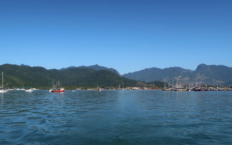 boats are on the water near mountains and buildings