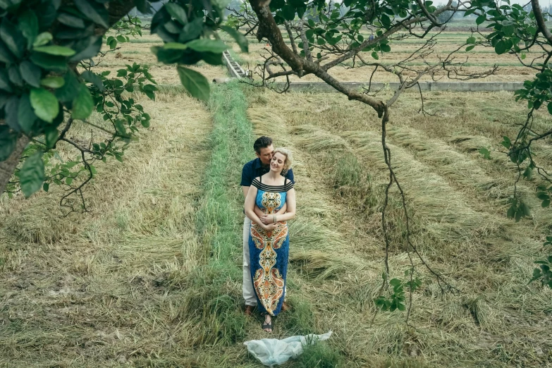 a couple that is standing in the grass