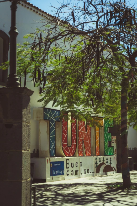 the outside view of a business sign with trees and buildings behind it