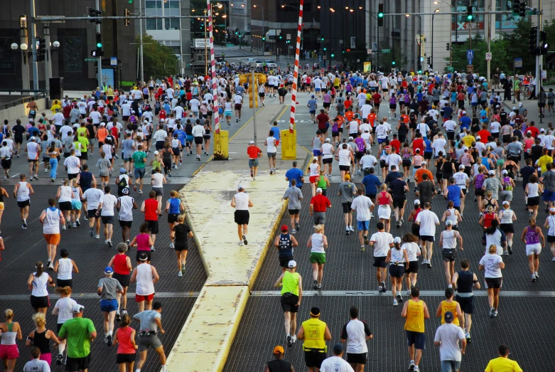 a lot of people on the sidewalk running in a marathon