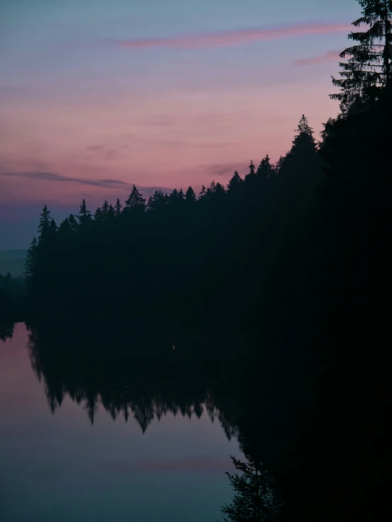 the lake reflects the sky as the sun sets