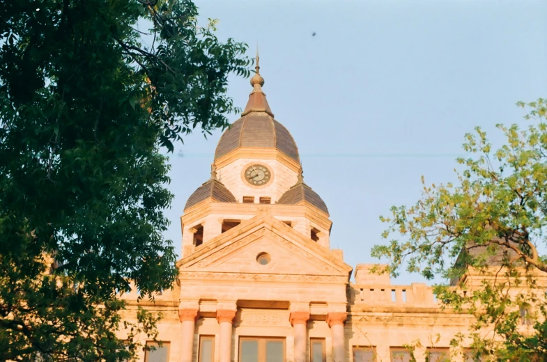 a clock tower above a building surrounded by trees