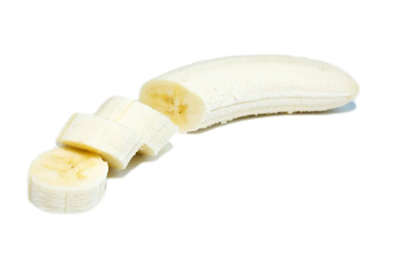 a banana sliced into small pieces on a white surface