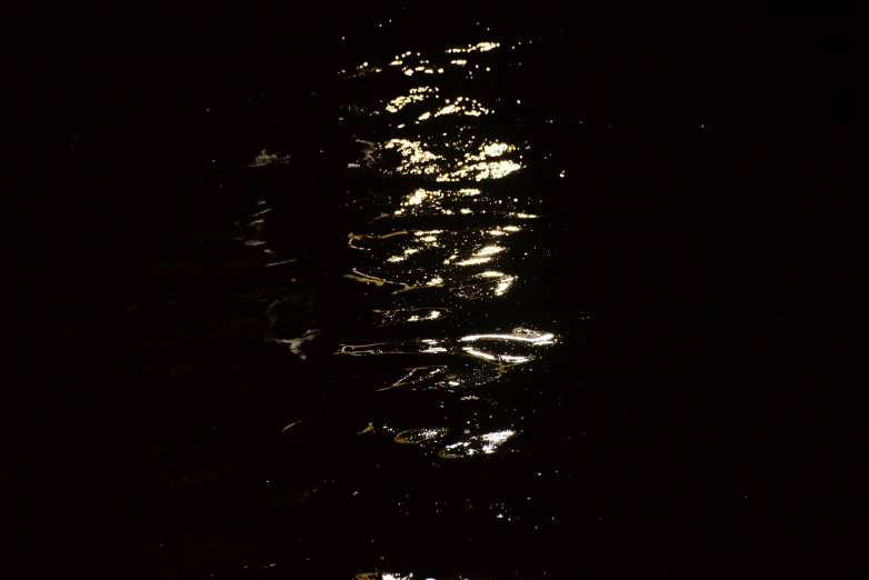 some dark water is shining from behind a buoy