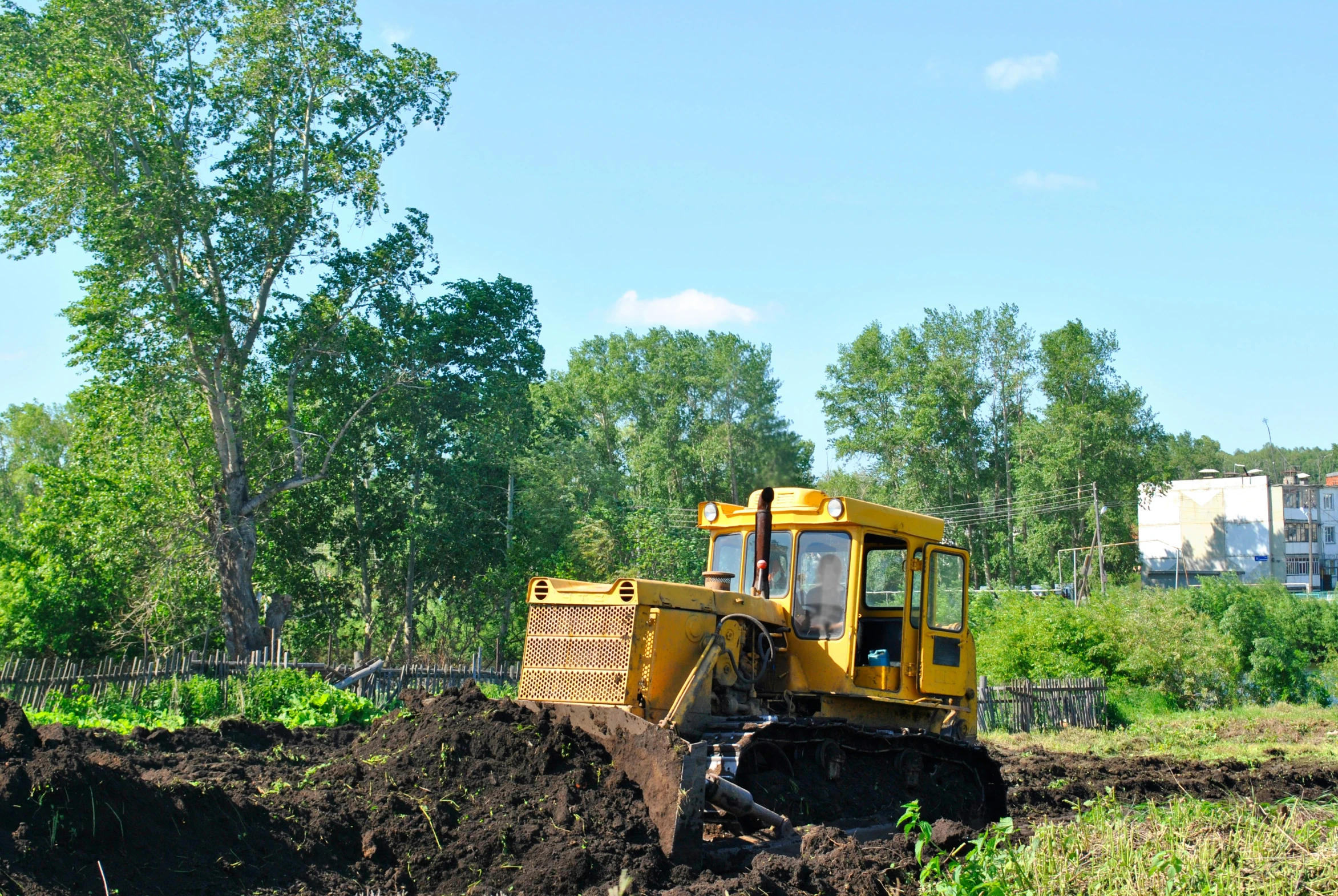 a small yellow machine digging the ground in the forest