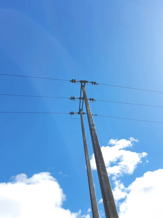 the three poles have electrical wires above them