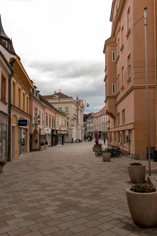 a city street with buildings and people walking