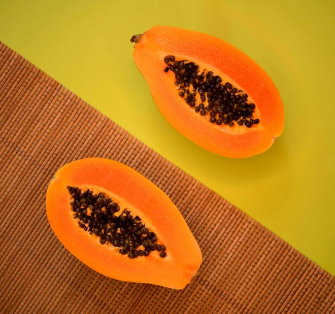 two papaya halves sitting on top of a rug