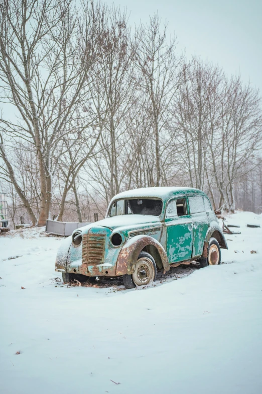 old rusty truck in snowy, icy landscape near tree