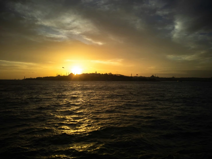 the sun is setting over the horizon as viewed from a boat