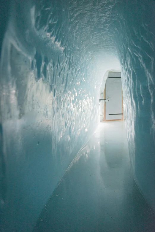 a long narrow tunnel with white foam on the floor and water on both sides