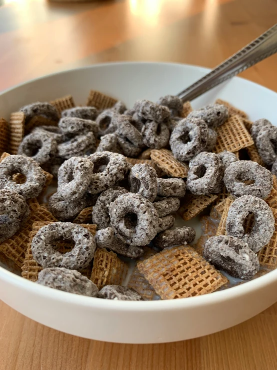 a bowl filled with cereal and topped with a silver spoon