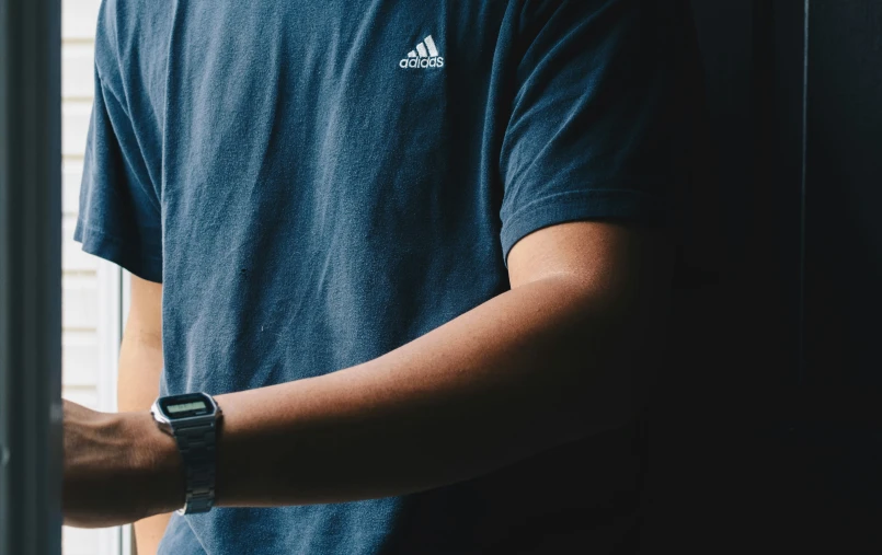 man wearing smart watch with one hand holding glass