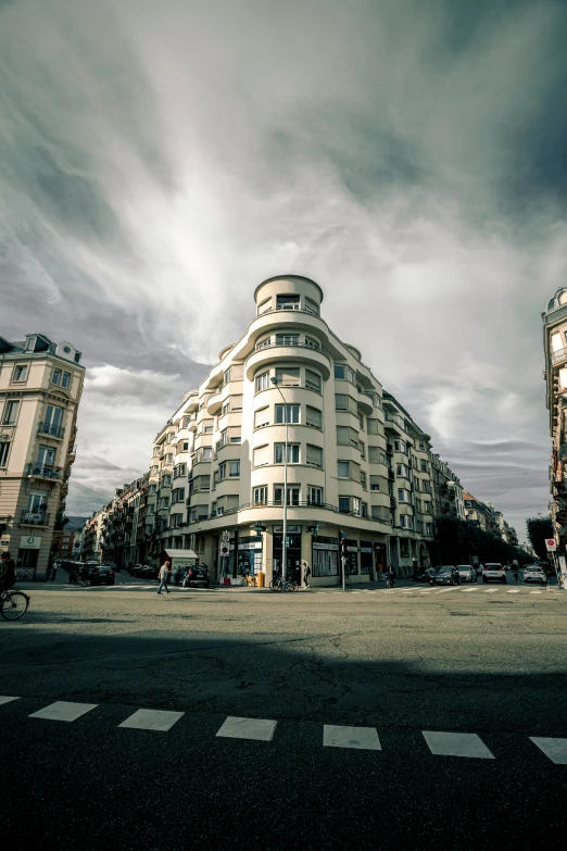 three buildings on a street with storm clouds in the sky