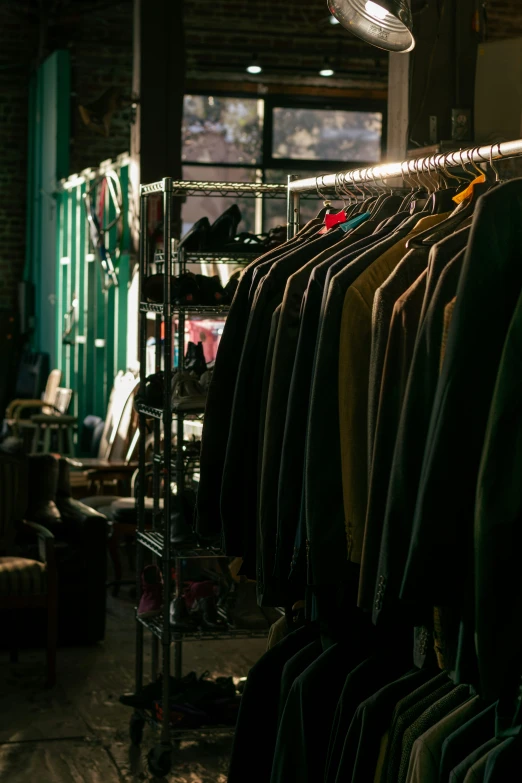 clothes are stacked up in a store near some windows