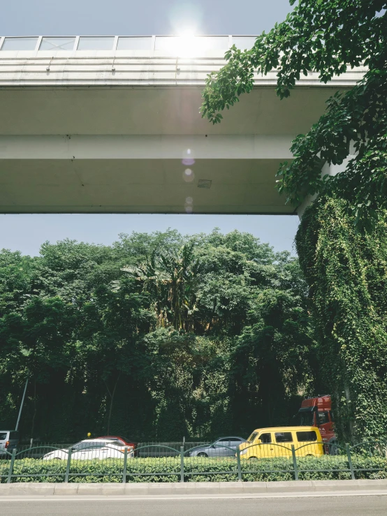 a street with cars parked in a parking lot underneath an overpass