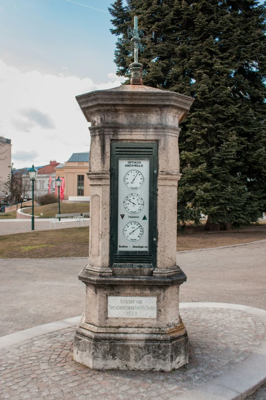 a large, concrete clock with weathervane on the side