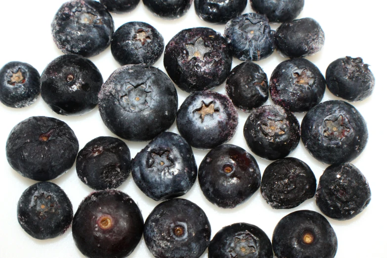 a pile of blueberries are displayed together