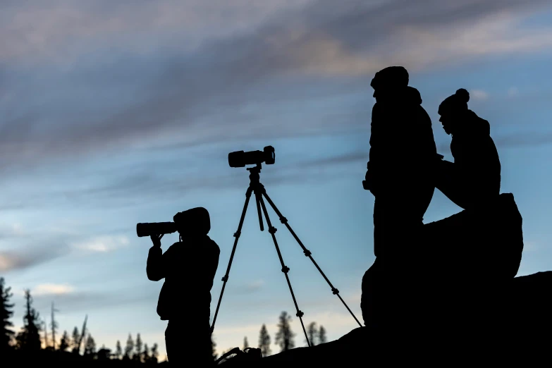 two people standing in the dirt with a camera