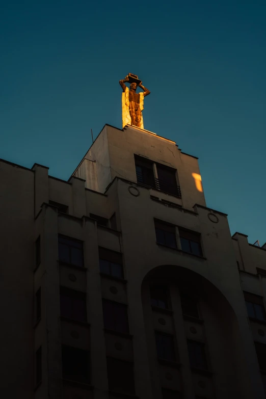 an elaborate gold statue atop a building on the horizon