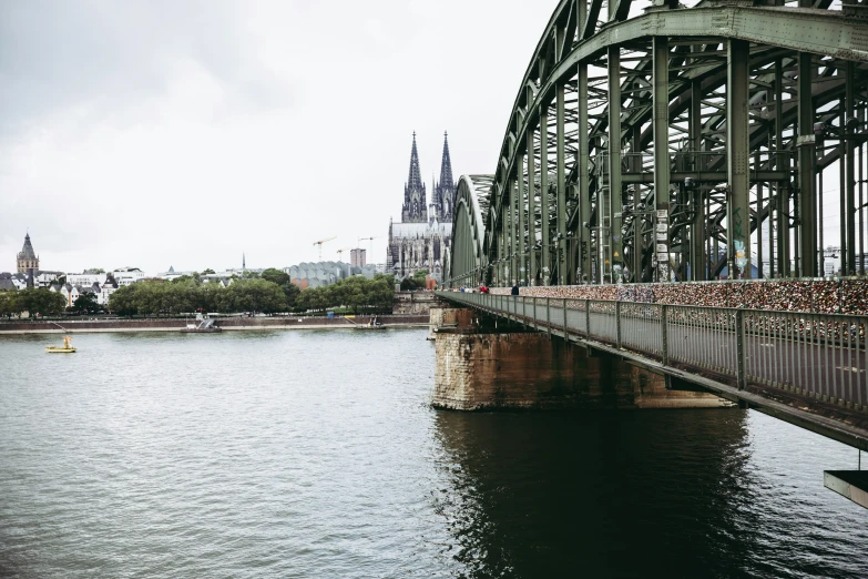 a boat in the water near a bridge with a very tall building