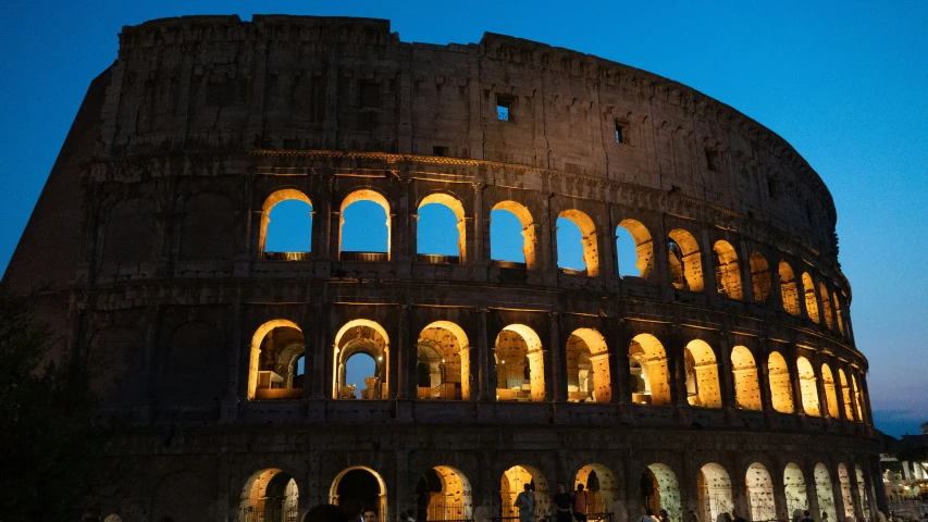 an ancient roman building with an illuminated window on the top