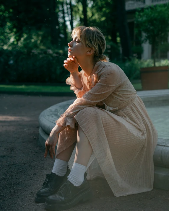 woman sitting on ground while looking away in large open area