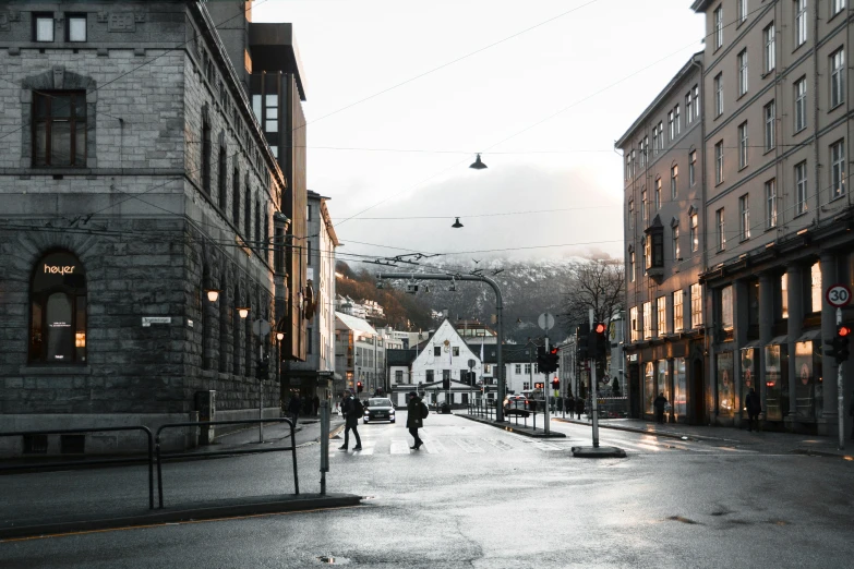 two people are walking in a city street with buildings and street lights