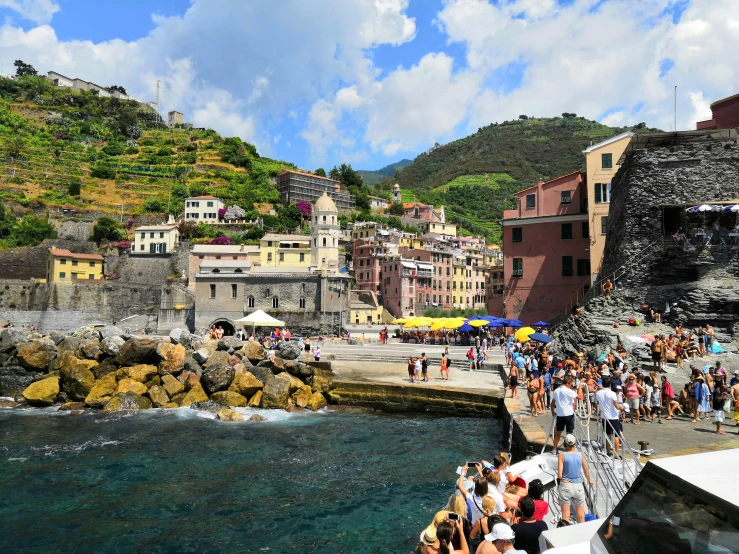 people on a pier and some buildings on the hill