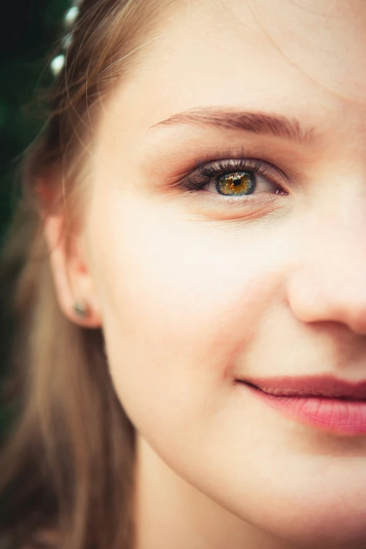 a smiling woman's eyes are open with light brown makeup