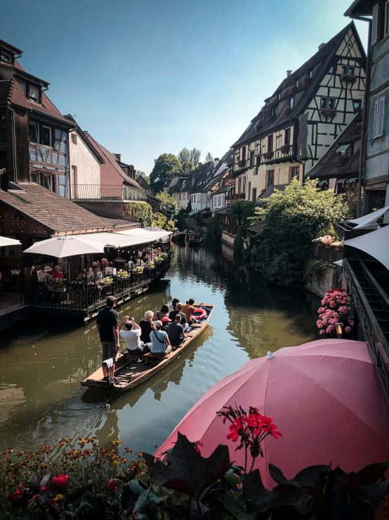 people sit in a boat with an umbrella over their head