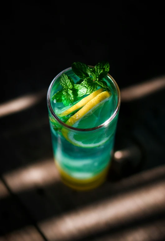 a green drink with lime and a lemon slice on the top